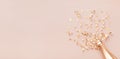 Golden champagne bottle with confetti stars, holiday decoration and party streamers on light pink background. Christmas, birthday Royalty Free Stock Photo