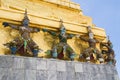 Golden chedi with supporting giants statues at Emerald Buddha temple in Bangkok, Thailand in the Grand Palace Royalty Free Stock Photo