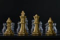 Golden chess are facing silver chess on black background. Business strategy, business competition, challenge or teamwork concept Royalty Free Stock Photo