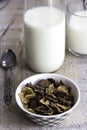 Golden and chocolate cornflakes in a bowl and a glass of milk on the wooden table Royalty Free Stock Photo