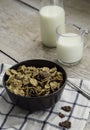 Golden and chocolate cornflakes in a bowl and a glass of milk on the wooden table Royalty Free Stock Photo