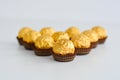 Golden chocolates against a white background