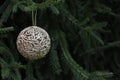 Golden Christmas ball on the fir tree. Close-up of beautiful luxury ornament