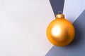 Golden Christmas ball at the intersection of four shades of gray with copy space.