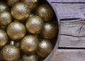 Golden Christmas balls in a silver bowl on wooden background.Winter holidays festive decoration. Merry Christmas,Happy New Year. Royalty Free Stock Photo