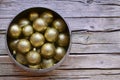 Golden Christmas balls in a silver bowl on wooden background.Winter holidays festive decoration. Merry Christmas,Happy New Year. Royalty Free Stock Photo