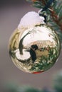 Golden Christmas decoration with reflection of photographer. Christmas ball powdered with snow. Soft focus Royalty Free Stock Photo