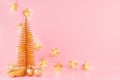 Golden Christmas decorations with Christmas tree, glitter balls, glowing stars garland on soft light pink background, copy space. Royalty Free Stock Photo