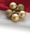 Golden Christmas and New years eve balls on a red Santa Claus hat on white surface. Copy space. Winter holiday theme background Royalty Free Stock Photo