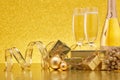 Golden Christmas ornaments, gift boxes, champagne bottle, champagne flutes on festive gold background. Christmas and New Year Royalty Free Stock Photo