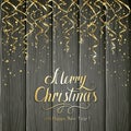 Golden Christmas tinsel on black wooden background