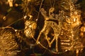 Golden Christmas tree toy in the form of a deer, tinsel and shining garlands on a dark background. New Year 2021. Selective focus. Royalty Free Stock Photo