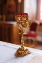 Golden church candlestick of one kerosene candle on table close-up