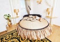 Golden classical bedroom interior with round bed, carpet and small table Royalty Free Stock Photo
