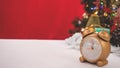 Golden clock decorated in Christmas celebration theme on white table reb background with copy-space, family spent time together in Royalty Free Stock Photo