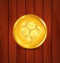 Golden coin with clover on brown wooden texture for St. Patrick Royalty Free Stock Photo