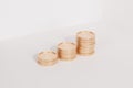 Golden coin stacks growing graph on white background, business investment and saving money concept, realistic 3d render