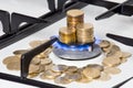 Golden coins on gas cooker Royalty Free Stock Photo