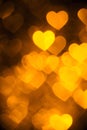 Golden color heart bokeh background photo. Abstract holiday, celebration backdrop. Royalty Free Stock Photo