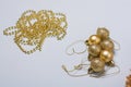 Golden colored Christmas tree decorations. Beads, baubles, bulbs on light background. Plastic not eco friendly decor