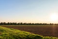 Golden and colorful sunset over the freshly plowed field, cereal fields with lens flare Royalty Free Stock Photo