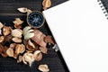 Golden compass put on dried leaves and blank notebook on wooden retro black table. Copy space for text and content Royalty Free Stock Photo