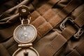 Golden compass on tactical or travel backpack, shallow DOF, focus on dial. Concept for direction, travel, guidance or assistance