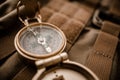 Golden compass on tactical or travel backpack, shallow DOF, focus on dial. Concept for direction, travel, guidance or assistance