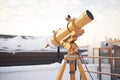 golden computerized telescope on a snowy rooftop Royalty Free Stock Photo