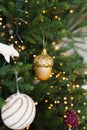 Golden cone toy is hanging on the Christmas tree with lights