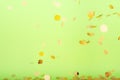 Golden confetti falling on the bold neon green background, holiday celebration backdrop