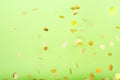 Golden confetti falling on the bold neon green background, holiday celebration backdrop