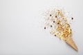 Golden confetti and streamers with party cracker on white background, top view. Space for text