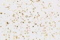 Golden confetti on white background Festive party or holiday glitter backdrop