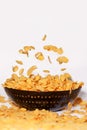 Golden cornflakes falling in a bowl - isolated