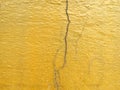 Golden cracked concrete wall surface.