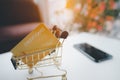 Golden credit card in the Shopping Cart against smartphone on white table Royalty Free Stock Photo