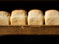 Golden, crisp, fresh bread on the wooden counter of a bakery or store. Homemade country bread, close-up. The concept of delicious