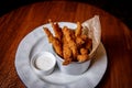 Golden crisp fried crumbed chicken nuggets served in a metal dish as an appetizer or finger food on bar background