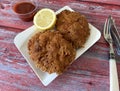 Chicken tenders with ketchup and lemon. American popular snack or main course.