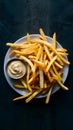 Golden crispy fries temptingly served with sauce on a dark background