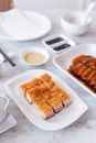 Golden Crispy Pork Belly cut in cube served with mustard sauce and hot tea with chopsticks Royalty Free Stock Photo