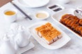 Golden Crispy Pork Belly cut in cube served with mustard sauce and hot tea with chopsticks Royalty Free Stock Photo