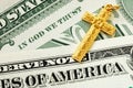 A golden cross on the dollar bills