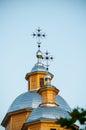 Golden cross and the dome of the old wooden Orthodox church against the blue sky. Close-up Royalty Free Stock Photo