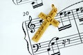 A golden cross on the top of a music sheet Royalty Free Stock Photo