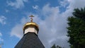 The golden cross on top of Russian Orthodox Church at the old city under blue sky with fluffy clouds Royalty Free Stock Photo