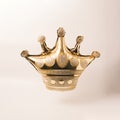Golden crown shaped floating balloon on a beige background.