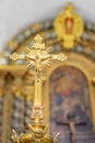 golden crucifix in focus with blurred altar in the background inside the Igreja Matriz de Colares Nossa Senhora da AssunÃ§Ã£o