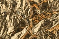 Golden crumpled shiny metallic paper. Yellow tinfoil texture for holiday. Glossy crinkled kitchen foil background